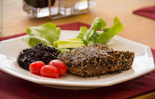 Кусок мяса на тарелке с рисом и овощами 