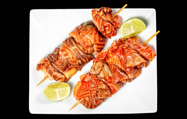 Шашлык на шпажках на белой тарелке с лимоном