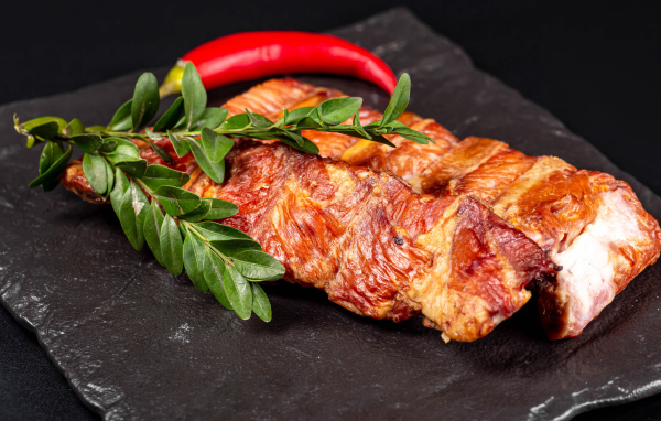 Копченые свиные ребрышки с зелеными листьями