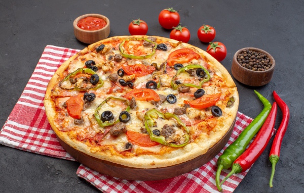 Большая ароматная пицца с помидорами и перцем на сером столе 