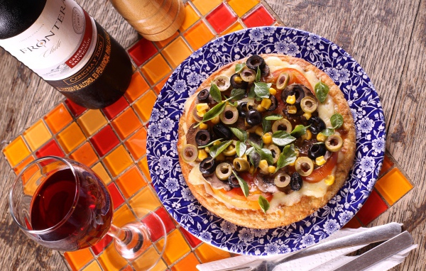 Итальянская пицца с оливками на столе с вином