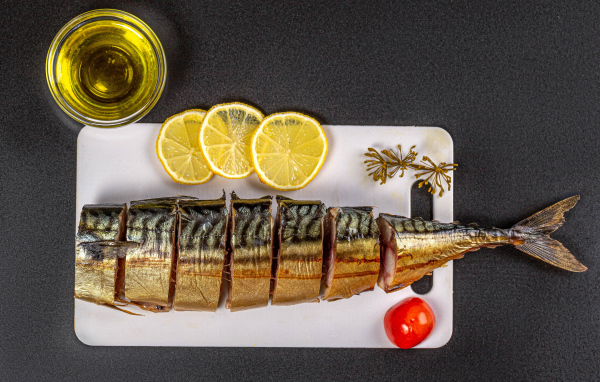 Аппетитная скумбрия на доске с лимоном и маслом