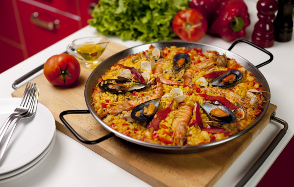 Плов с морепродуктами на столе с овощами