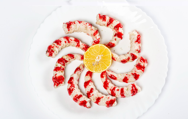 Tiger prawns on a plate with lemon on a white background