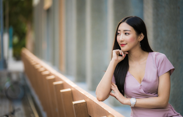 Красива девушка азиатка задумчиво смотрит вдаль
