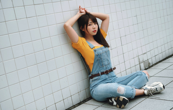 Девушка азиатка в джинсовом комбинезоне 