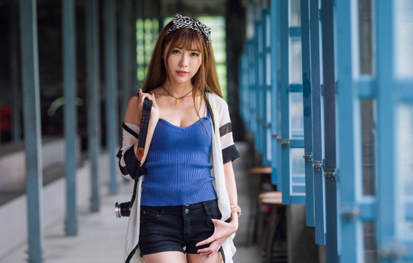 Девушка азиатка с фотоаппаратом в руках 