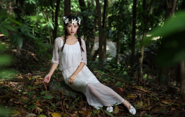 Красивая девушка азиатка в белом платье  в лесу