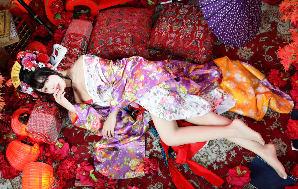 Красивая девушка азиатка в кимоно лежит на полу