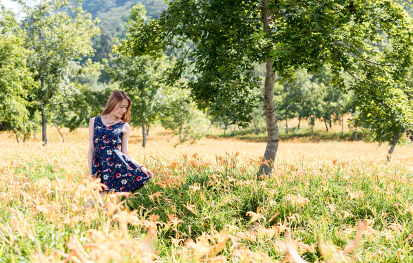 Красивая азиатка гуляет по высокой траве