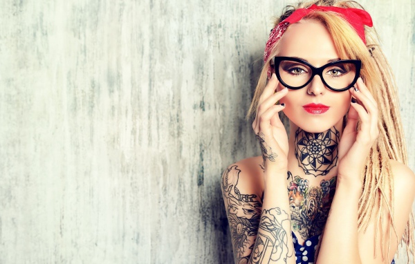 Красивая блондинка в очках с татуировками на теле