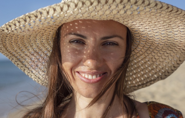 Beautiful brown-eyed girl in a big straw hat