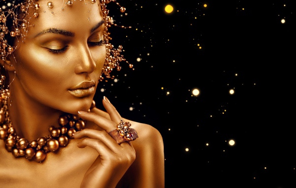 Красивая девушка в золотой краске на черном фоне