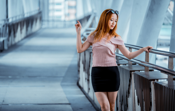 Красивая рыжеволосая девушка азиатка в черной юбке