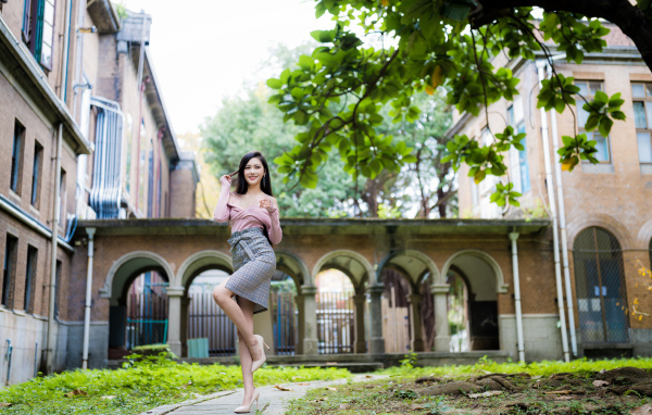 Красивая стройная азиатка на фоне здания