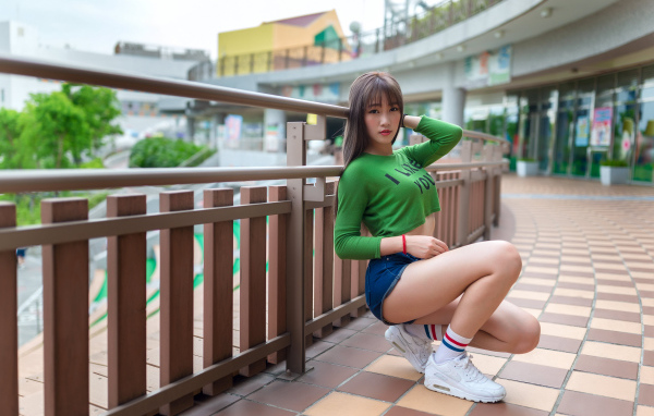 Красивая молодая азиатка в белых кроссовках 