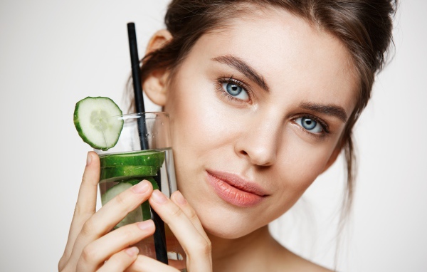 Голубоглазая девушка с огуречным напитком в руке 