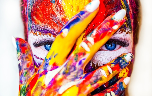 Голубоглазая девушка с лицом в краске на белом фоне