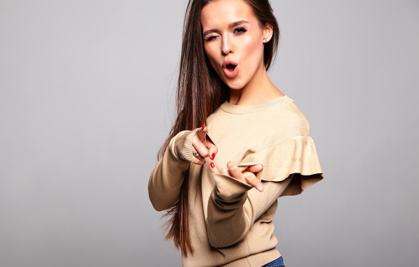 Яркая длинноволосая девушка на сером фоне 