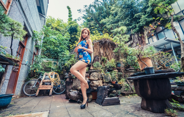 Милая азиатка в коротком платье у дома 