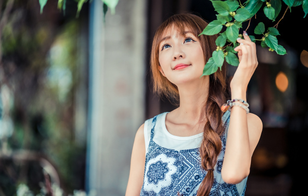 Милая девушка азиатка с косой на голове