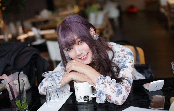 Милая девушка азиатка сидит за столиком