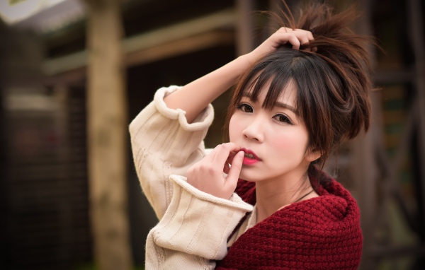Милая девушка азиатка с рукой в волосах 