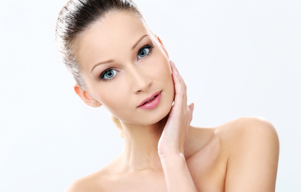 Нежная голубоглазая девушка без макияжа на белом фоне