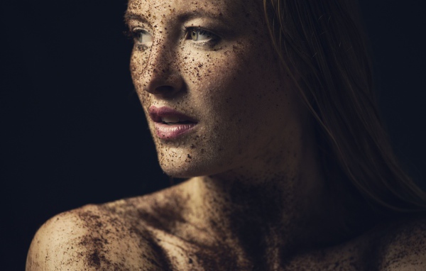 Грязная девушка в земле на черном фоне