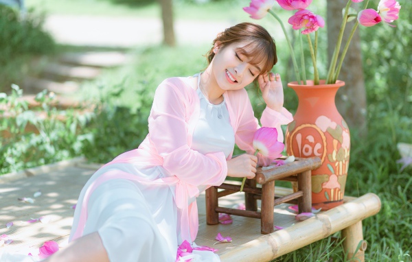 Мечтательная девушка азиатка с цветами лотоса