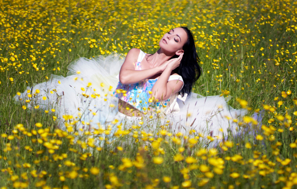 Девушка в красивом платье на траве с желтыми цветами