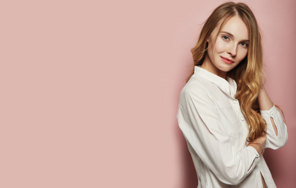 Девушка в белой рубашке на розовом фоне