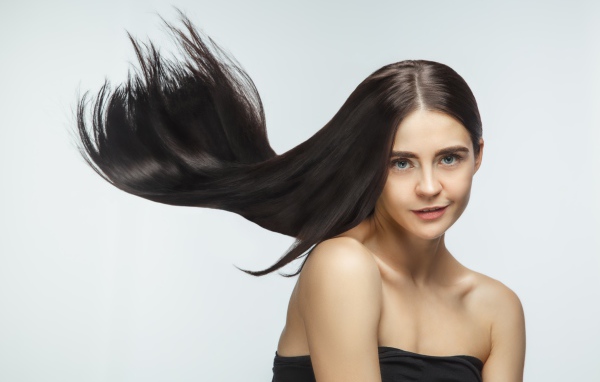 Длинные шелковистые волосы молодой брюнетки 