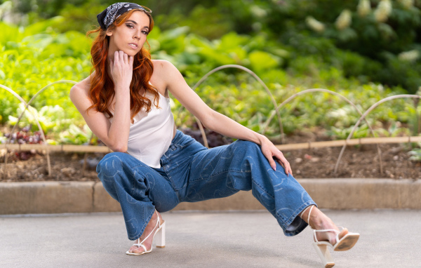 Рыжеволосая девушка в синих джинсах 