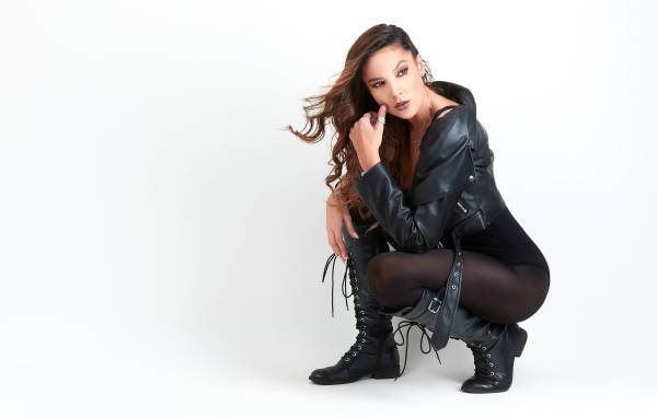 Девушка рокерша в черной куртке на белом фоне 