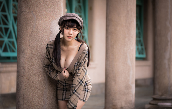 Сексуальная девушка азиатка стоит у колонны 