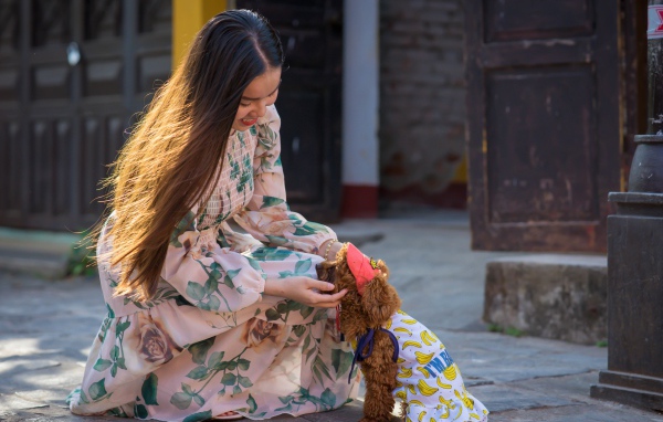 Улыбающаяся девушка азиатка с собакой 