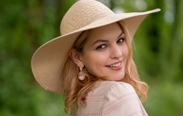 Улыбающаяся кареглазая девушка  в шляпе 