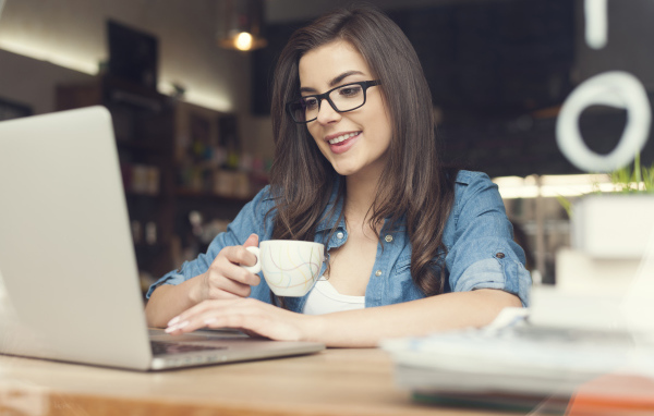 Улыбающаяся девушка в очках с ноутбуком