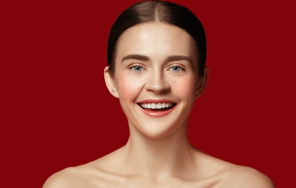 Улыбающаяся молодая девушка на красном фоне