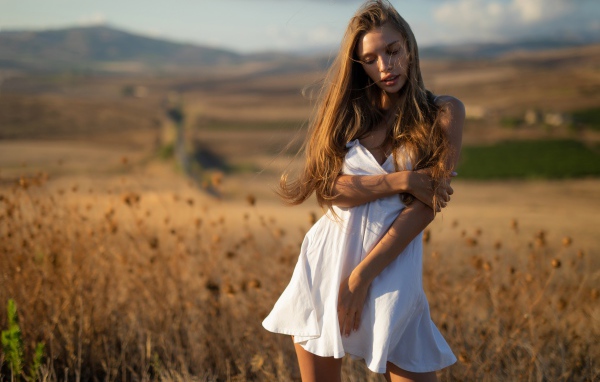 Нежная девушка в белом платье в лучах солнца 