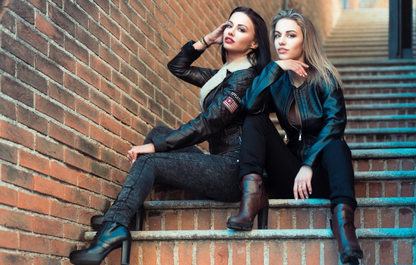 Две красивые девушки сидят на ступенях 