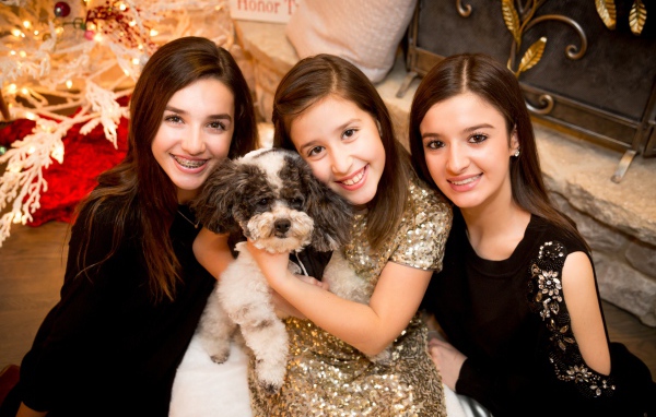 Три улыбающихся девушки с собакой на новый год