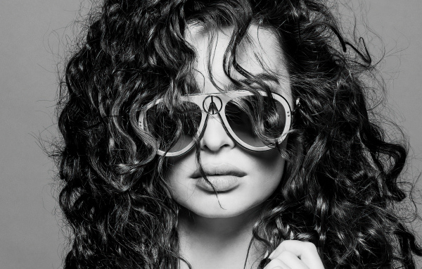 Модель Эмили Ратаковски в очках на сером фоне