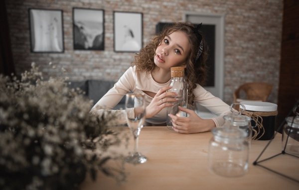 Молодая девушка модель сидит в кафе за столом