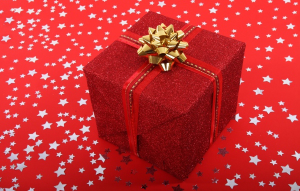 Big gift with a bow on a red background with stars