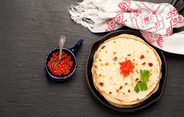 Тонкие блинчики с красной икрой на столе