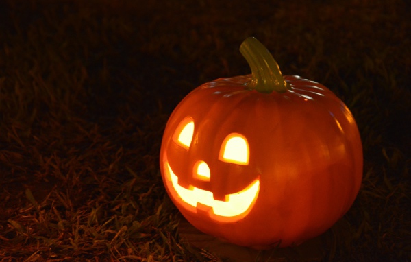 Светильник из тыквы на черном фоне на праздник Хэллоуин