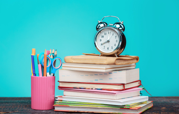Будильник, книги и канцелярские предметы для школы