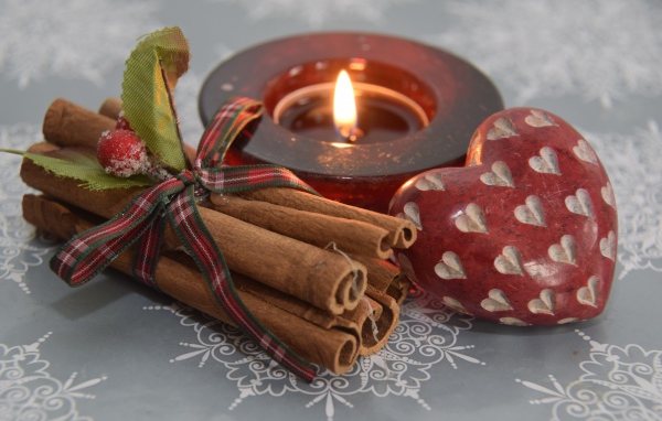 Корица, свеча и сердце на столе 